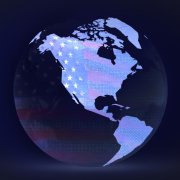 A globe with continents with the American flag looming in the background.